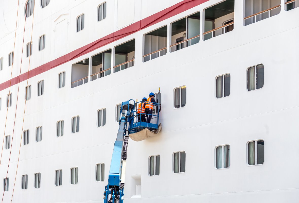 Workers working on side of ship